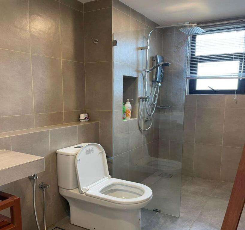 a bathroom with a shower and a toilet and a sink at DS Timurbay Residence in Kuantan