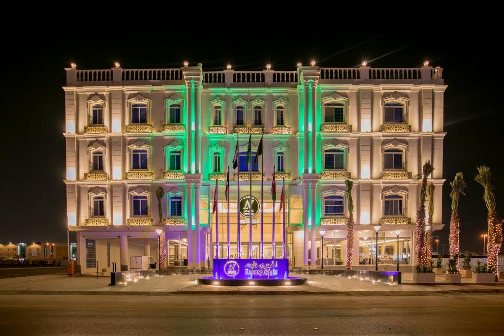 a white building with blue and green lights on it at Luxury Night Hotel in Riyadh