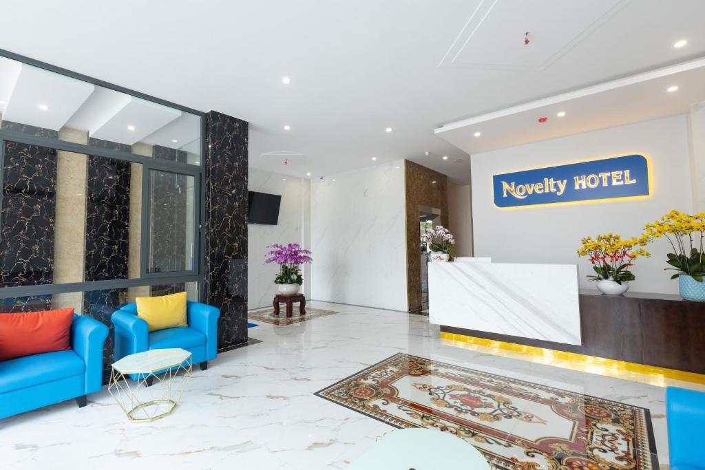 un hall d'un hôtel avec des canapés bleus et un panneau dans l'établissement Novelty Hotel, à Vung Tau