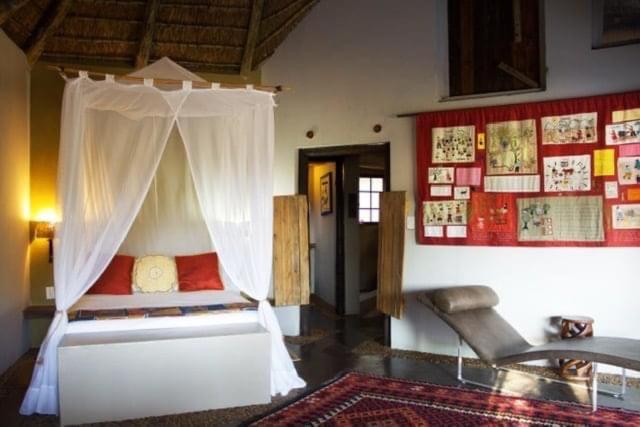 a bedroom with a bed with a canopy at Mogalakwena River Lodge in Alldays