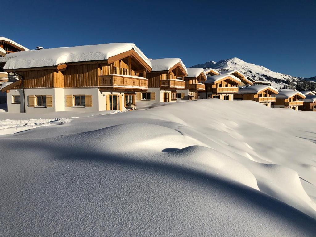 a ski lodge in the snow with a mountain at Filzstein Resort Chalet - Zillertal Arena, Hohe Tauern, Salzburgerland, Krimml, Hochkrimml in Krimml