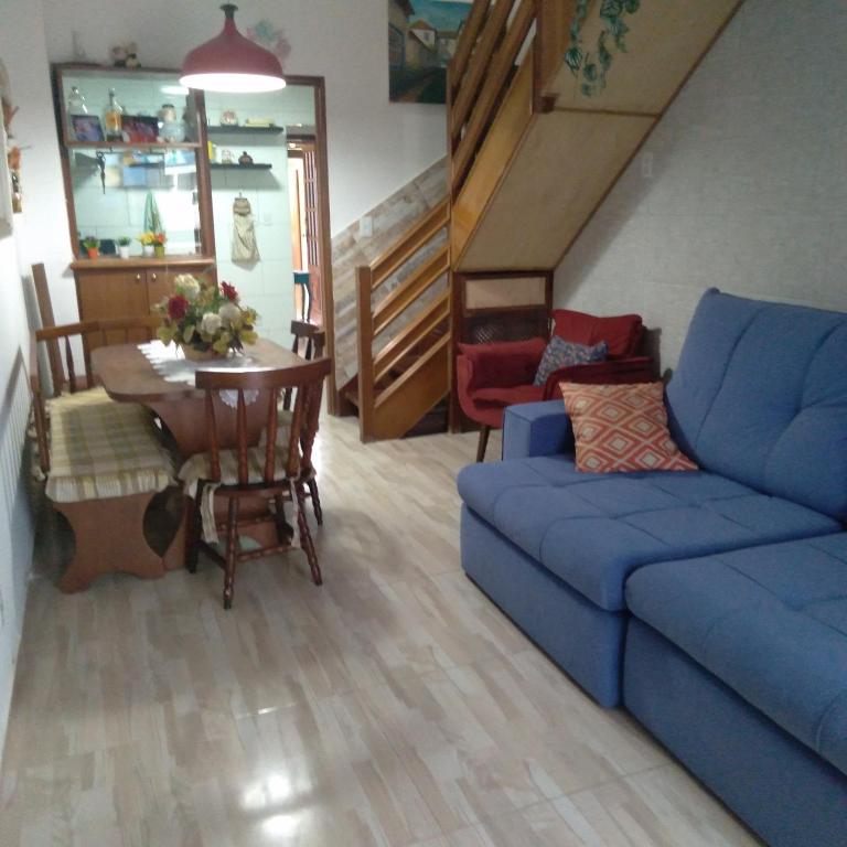 sala de estar con sofá azul y mesa en Casa temporada., en Cabo Frío