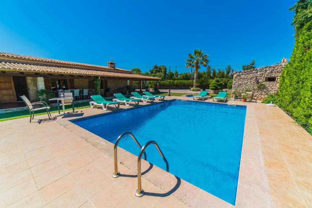 a swimming pool with chairs and a house at Ideal Property Mallorca - Moli in El Port