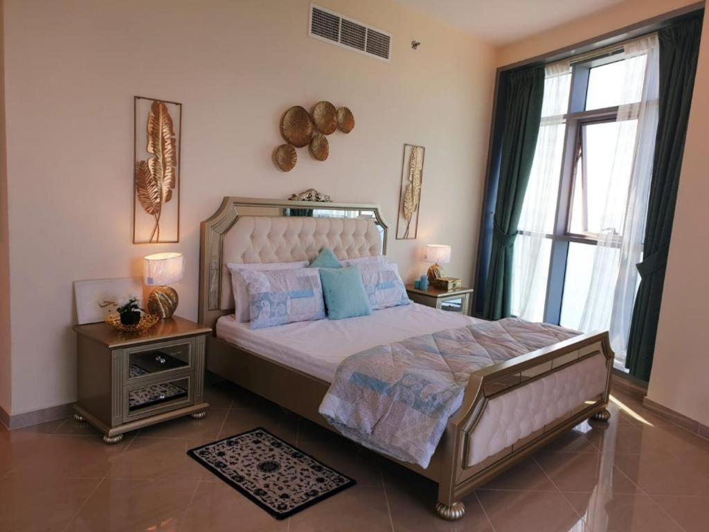 ein Schlafzimmer mit einem großen Bett mit blauen Kissen in der Unterkunft LUXURIOUS SEA VIEW APARTMENT FOR STAYS! in Ajman 