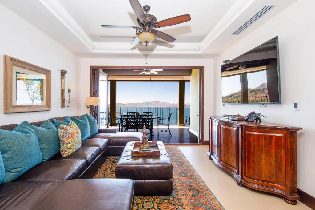 ein Wohnzimmer mit einem Sofa und einem Deckenventilator in der Unterkunft 360 Splendor 308A-Ocean View 2 Br -Breakfast Included! in Playa Flamingo