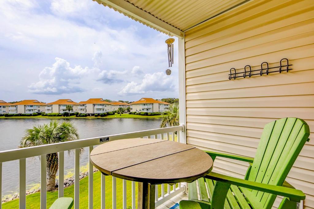 a table and chairs on a balcony with a view of the water at Beach Cottage at OD in Myrtle Beach