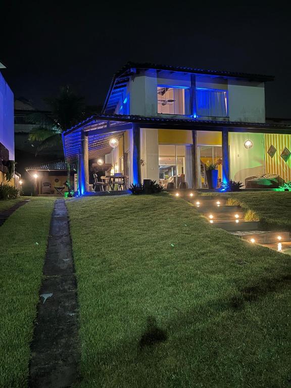 a house lit up at night with blue lights at Casa da Rô !!! Melhor casa frente ao mar de Ubu !!! in Anchieta