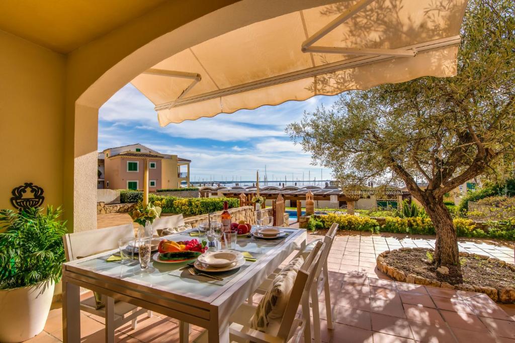 - une table à manger sur une terrasse avec un parasol dans l'établissement Blau Mari 2 PAX, à Sa Ràpita