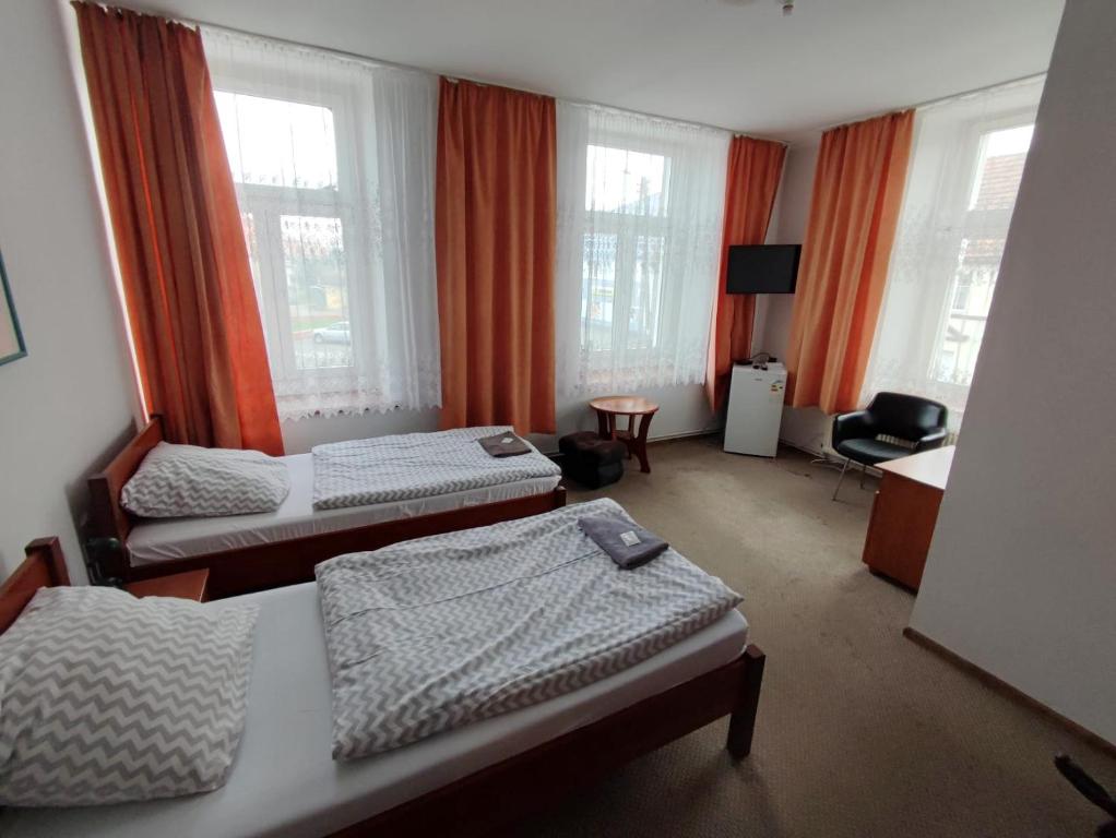 Habitación de hotel con 2 camas y escritorio en Hotel Stary Ratusz, en Kostomłoty