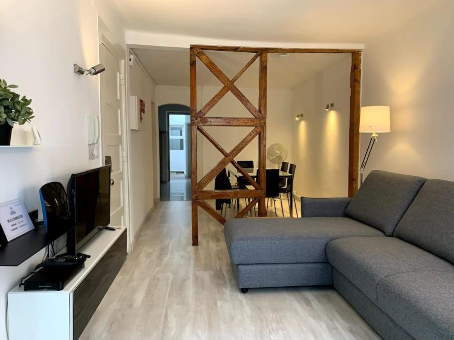 een woonkamer met een bank en een televisie bij Paz Apartment in Lissabon