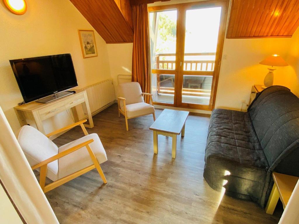 un salon avec un canapé et une télévision dans l'établissement Duplex moderne avec balcon, parking, cuisine équipée - FR-1-516-22, à Les Deux Alpes