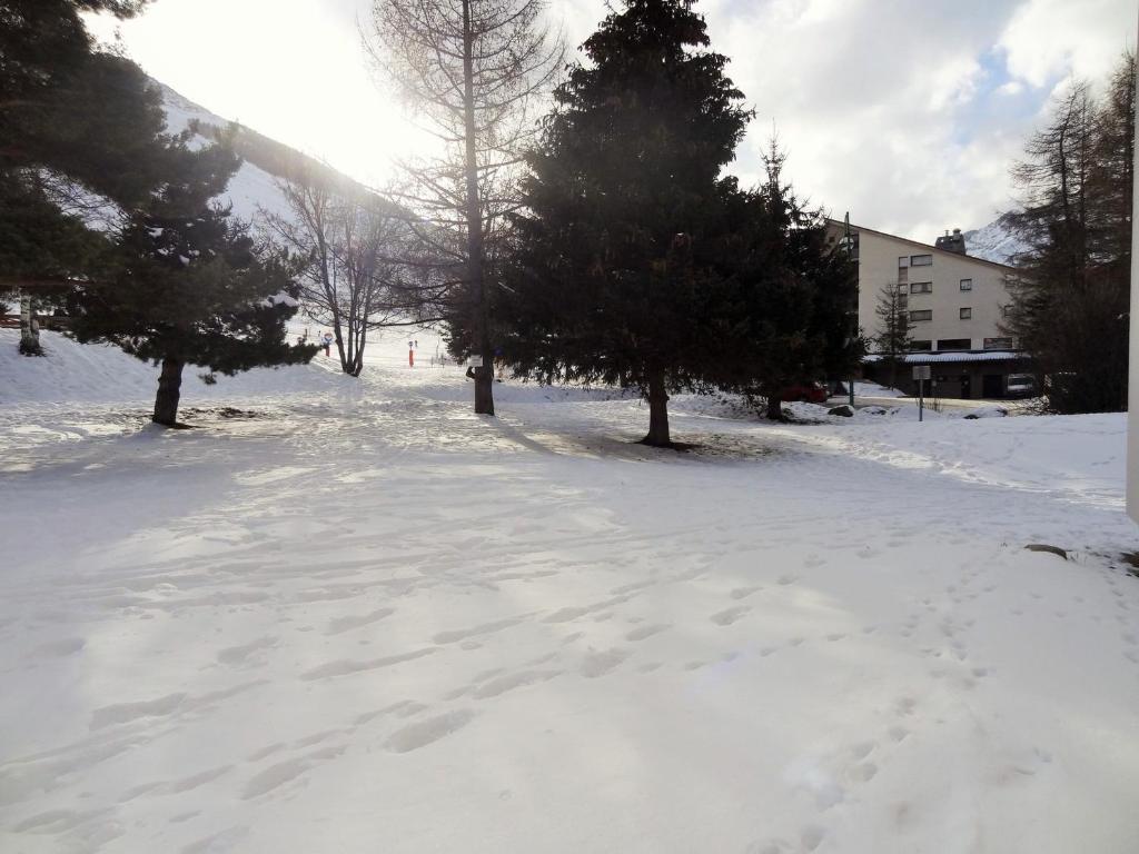 a snow covered street with trees and a building at Appartement Les Deux Alpes, 2 pièces, 4 personnes - FR-1-516-43 in Les Deux Alpes