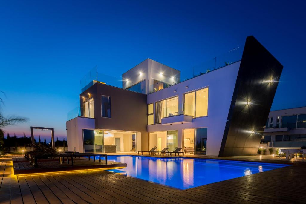 a large house with a swimming pool at night at Cove Seaview Villas - Neptune in Ayia Napa