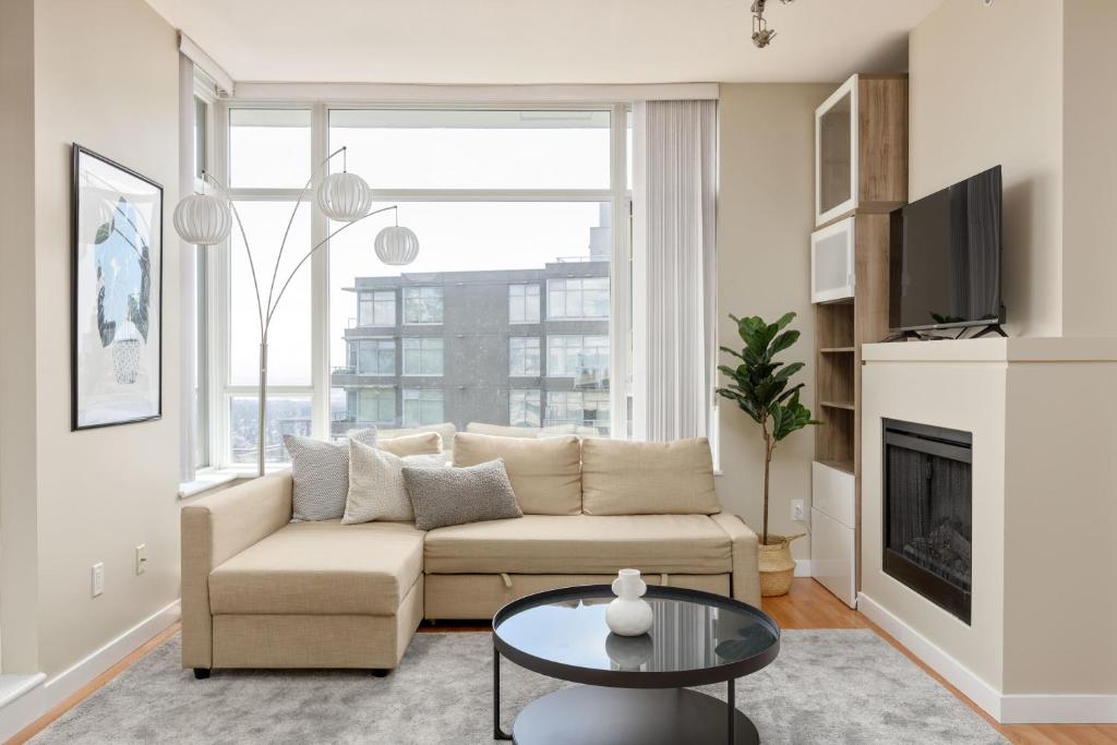 a living room with a couch and a table at Lovely 2 Bedroom condo with indoor Fireplace for 6 in Burnaby