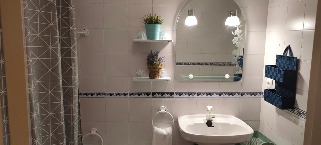 uma casa de banho com um lavatório e um espelho em Coqueto apartamento a un tiro de piedra de la playa del Portil em El Portil