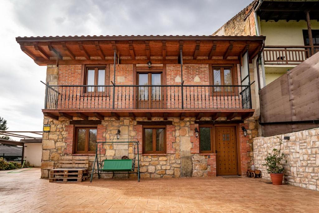 una casa de ladrillo con balcón en la parte superior en Casa Rural La Magdalena en Hoz de Anero