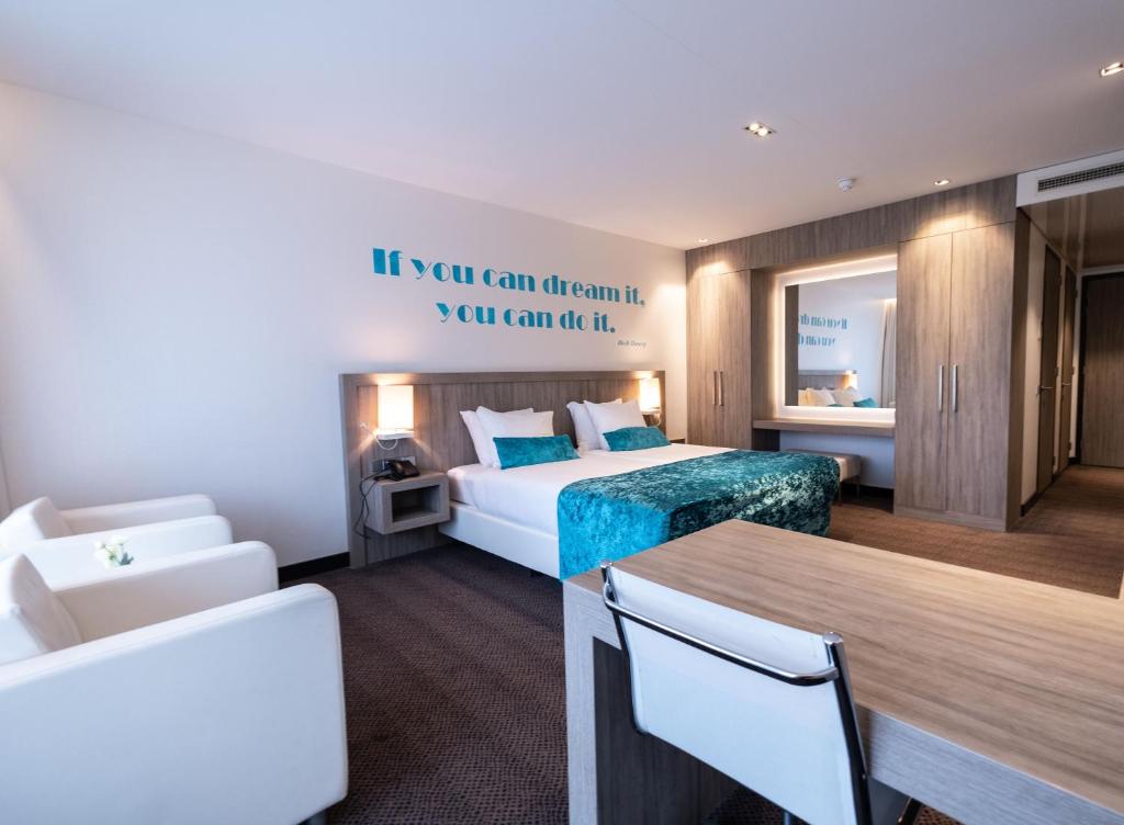 フィアーネンにあるVan der Valk Hotel Vianen - Utrechtのベッド、テーブル、椅子が備わるホテルルームです。