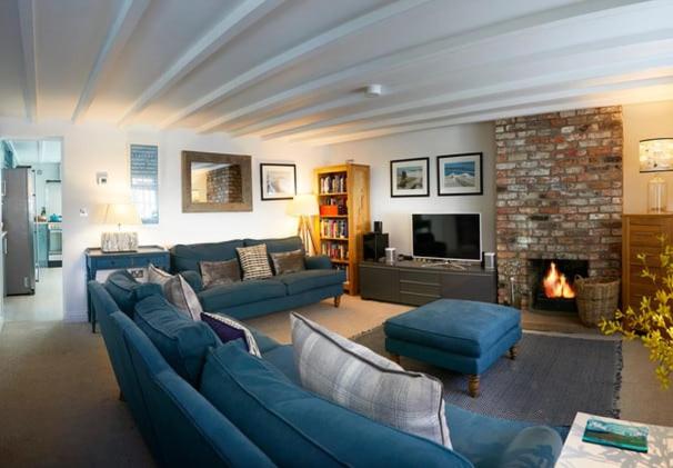 a living room with blue couches and a fireplace at Flora Dora - Luxury cottage - modern - central - ideal for groups and families in Filey