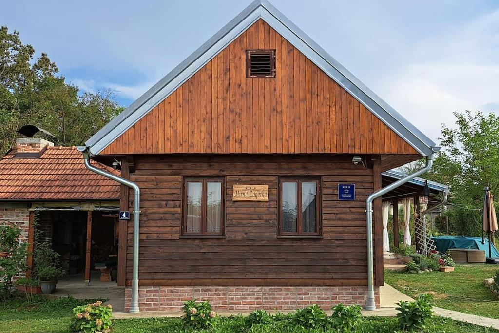 una pequeña casa de madera con techo marrón en Kuća za odmor Mirna Zagorka, 