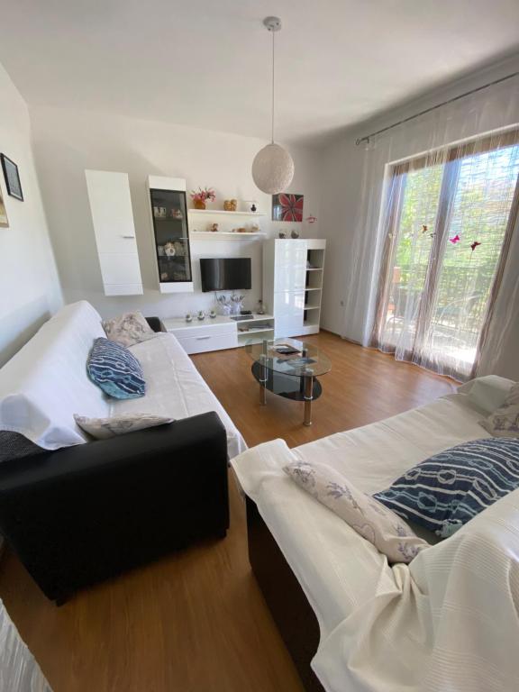 a living room with two beds and a table at Bright and spacious apartment with outdoor space in Kaštela