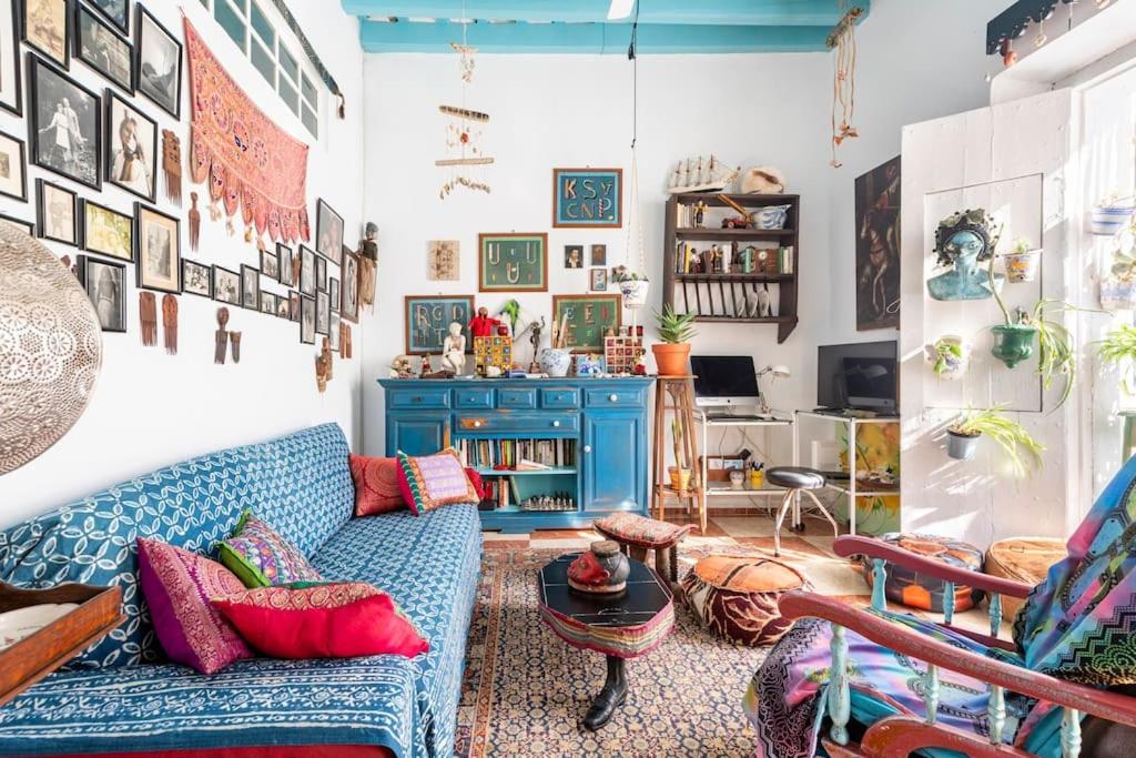 Una sala de estar con un sofá azul y una mesa. en Habitaciones La Pepa, en Cádiz