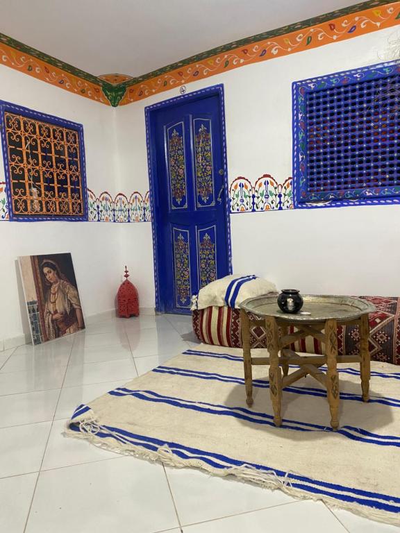 une chambre avec une table et une porte bleue dans l'établissement Hostel Essassi 23, à Marrakech
