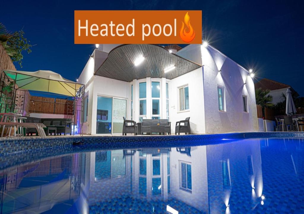 a heated pool in front of a house at night at Villa Casa By Sun And View in Eilat