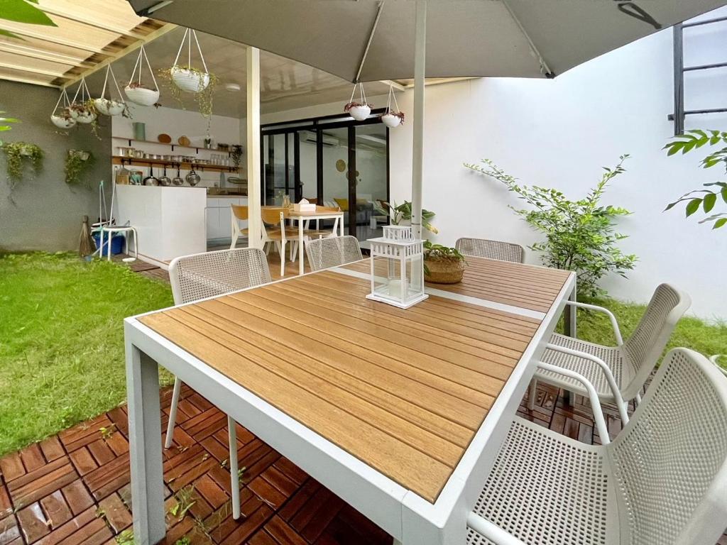 a table with chairs and an umbrella on a patio at Larisa Homestay Syariah in Padalarang