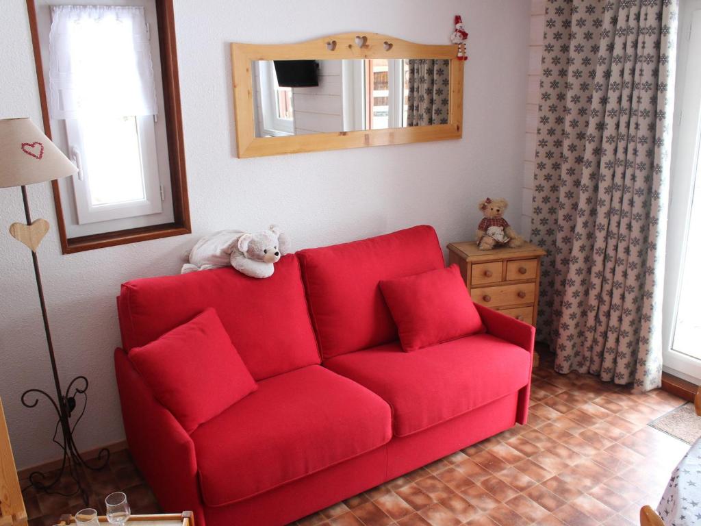 a red couch in a living room with a mirror at Appartement Valloire, 2 pièces, 4 personnes - FR-1-263-45 in Valloire