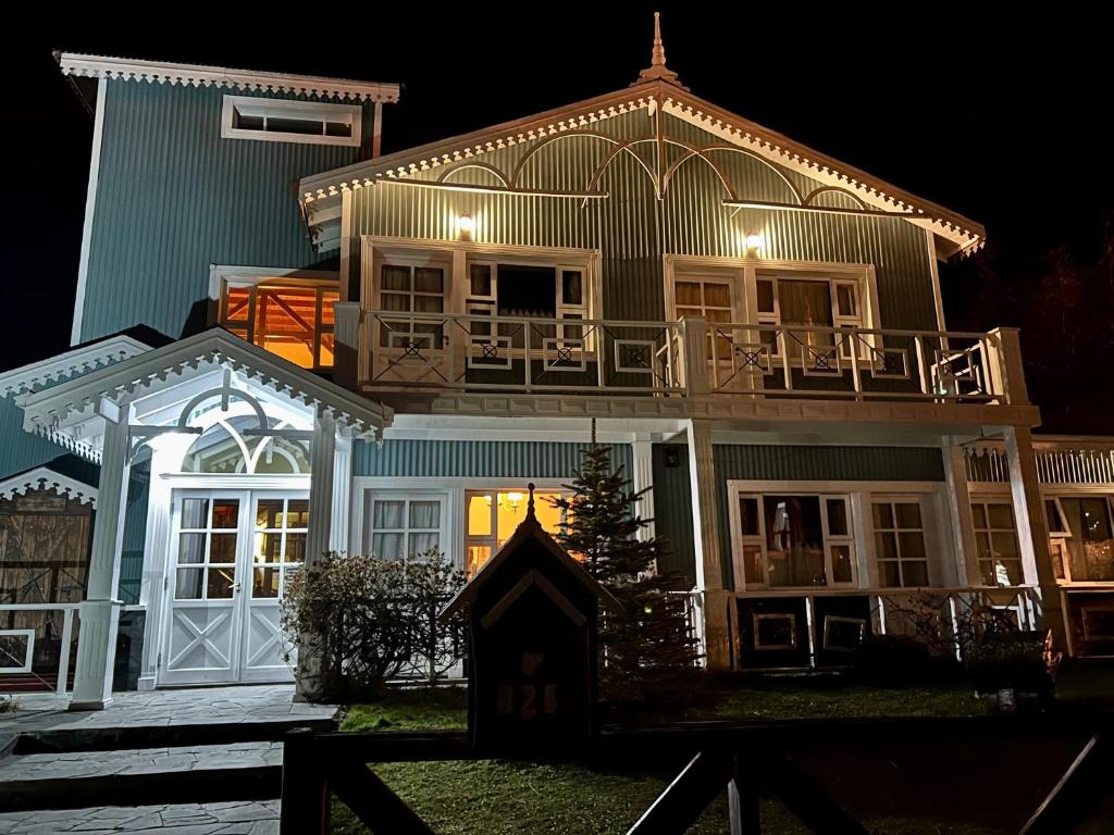 uma grande casa azul com uma varanda em cima em Hotel Campanilla em Ushuaia