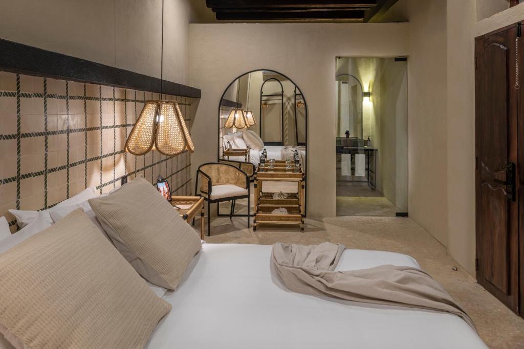 ein Schlafzimmer mit einem Bett, einem Stuhl und einem Schreibtisch in der Unterkunft Privado Selfservice Boutique Rooms in Cartagena de Indias