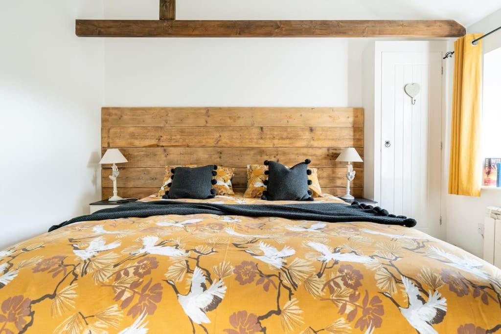 - une chambre avec un grand lit et une couverture jaune dans l'établissement New Listing - Idyllic cottage in a beautiful Kent setting, à Kent