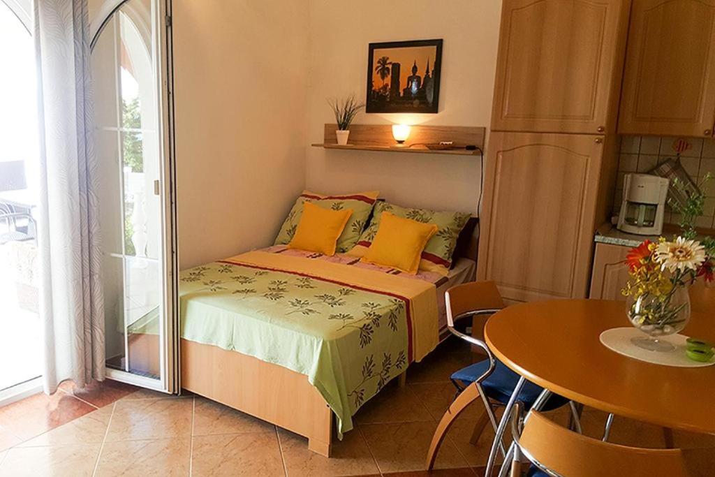 a small bedroom with a bed and a table at Villa Lilly 2 in Cesarica