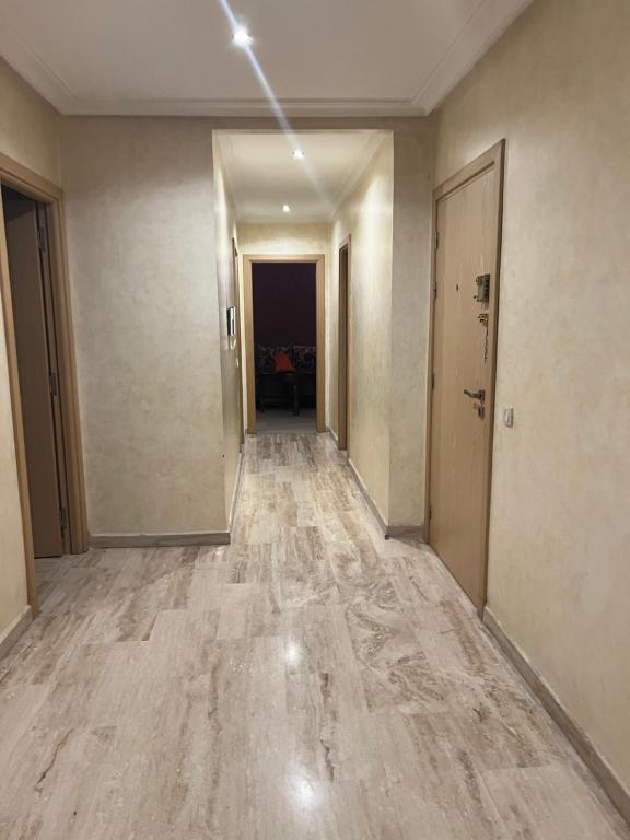 un couloir vide dans un bâtiment doté de parquet et de plafonds en bois dans l'établissement Résidence les champs N3, à Casablanca