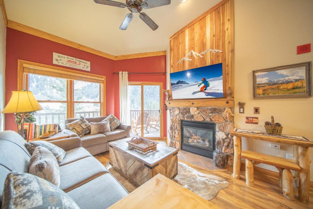 a living room with a couch and a fireplace at Hidden River Lodge 5977 in Keystone