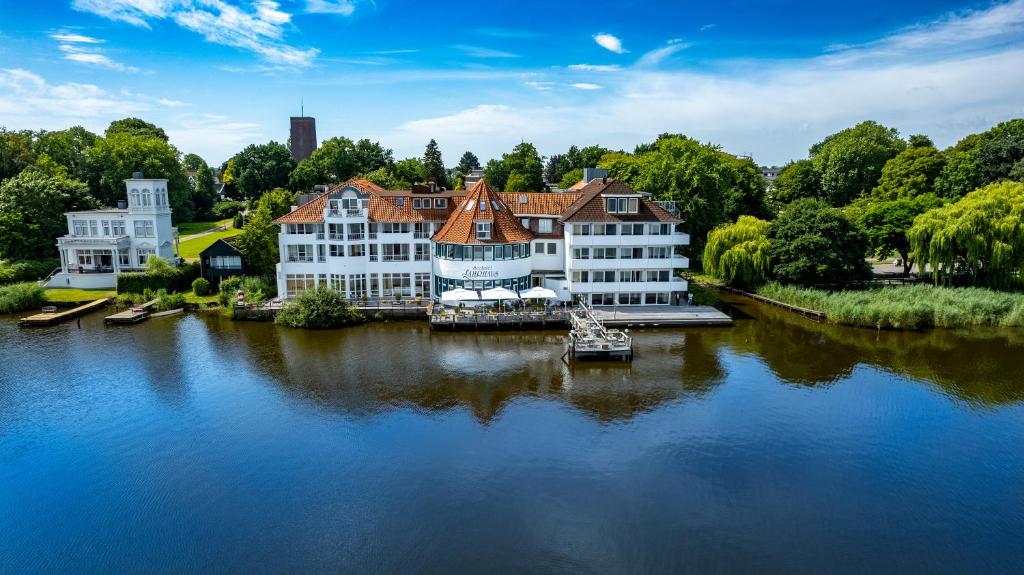 an aerial view of a large building on the water at Seehotel Fährhaus in Bad Zwischenahn