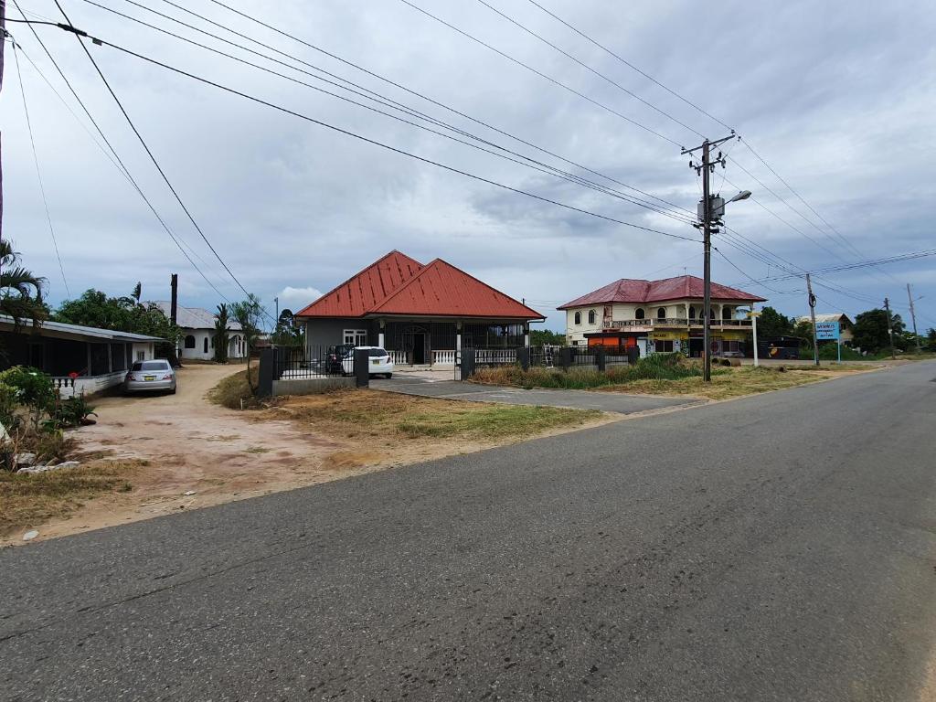 uma rua vazia com uma casa com um telhado vermelho em Chander's Villa em Paramaribo