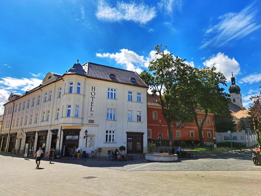 un gran edificio blanco en una plaza de la ciudad en Hotel Domus Collis, en Győr