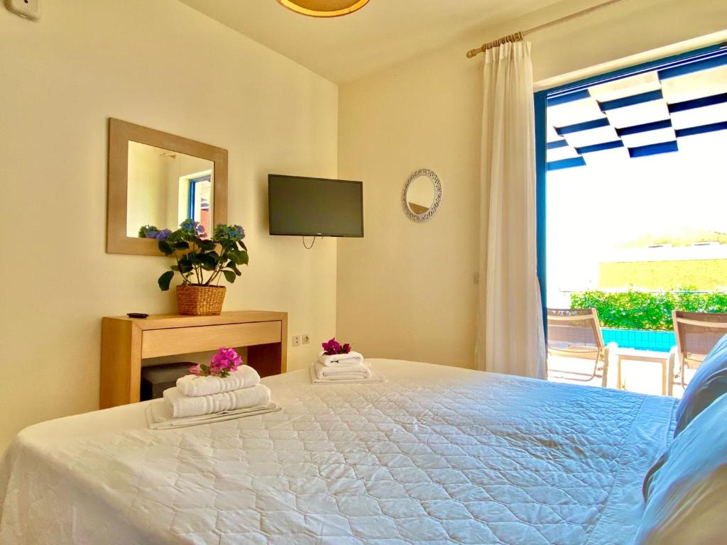 a bedroom with a large white bed with a window at Villa Barbati Pelagos with private pool by DadoVillas in Barbati