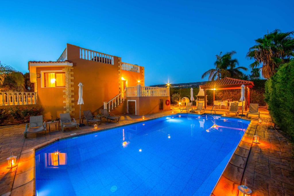 a large swimming pool in front of a house at Villa Polyxeni in Peyia