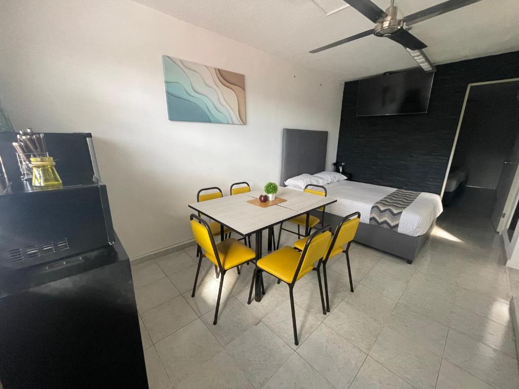 a dining room with a table and yellow chairs at Departamento Cancún in Cancún