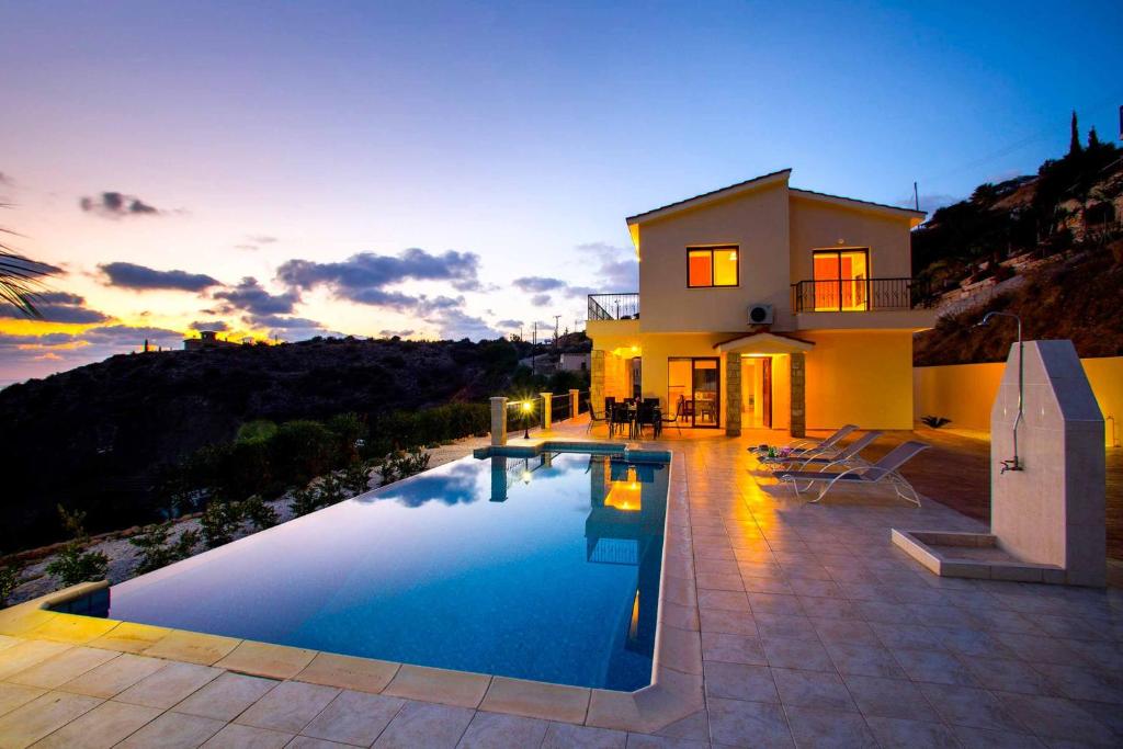 uma villa com piscina em frente a uma casa em Villa Blue Jadeite em Kissonerga