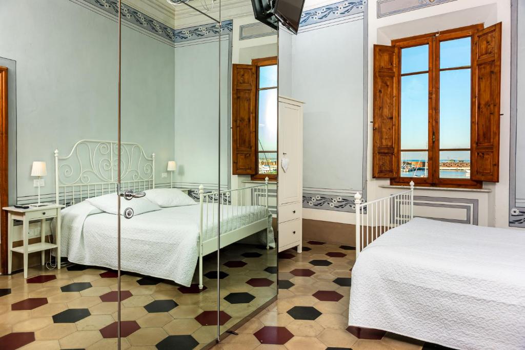 a bedroom with two beds and a glass wall at Villino Ermione in Marina di Pisa
