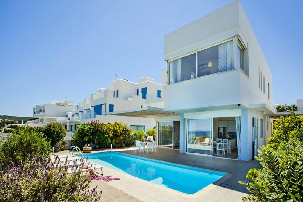 ein großes weißes Haus mit einem Pool davor in der Unterkunft Villa Melissa Selana in Protaras