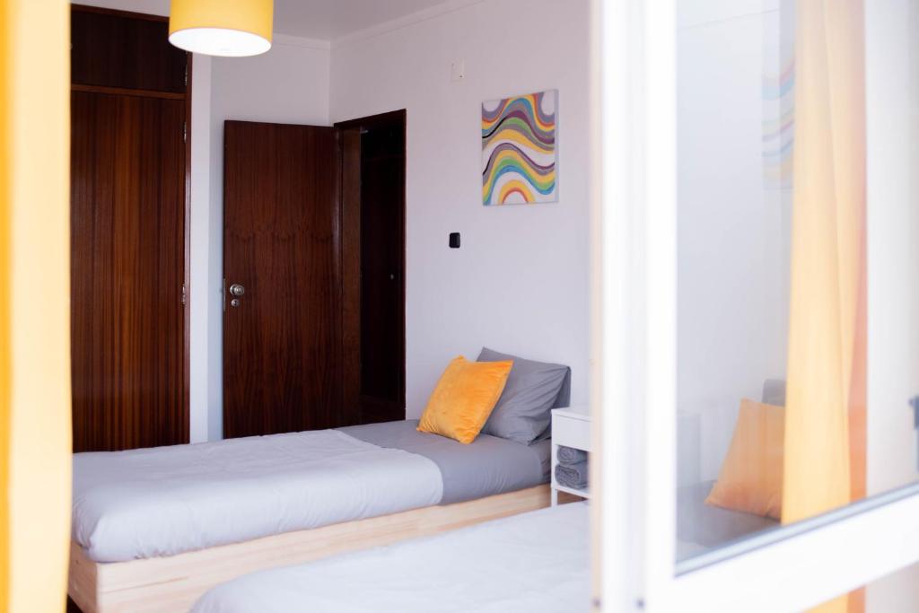 a room with two beds and a mirror at Baleal Surf Emotions in Baleal