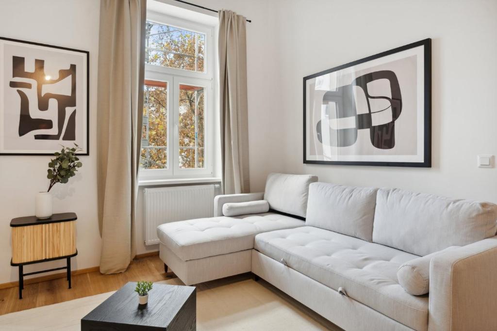 uma sala de estar com um sofá branco e uma mesa em Center Wien designer central modern apartment em Viena