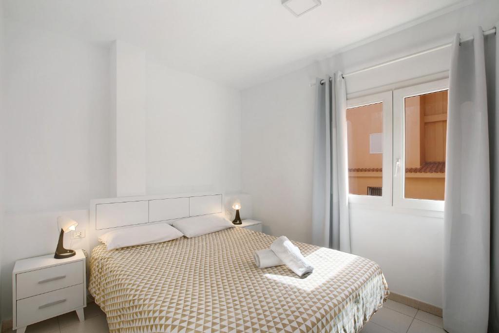 - une chambre blanche avec un lit et une fenêtre dans l'établissement Chipaz Candelaria, à Santa Cruz de Tenerife