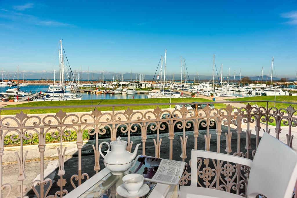 een balkon met een tafel en uitzicht op een jachthaven bij Villino Ermione in Marina di Pisa