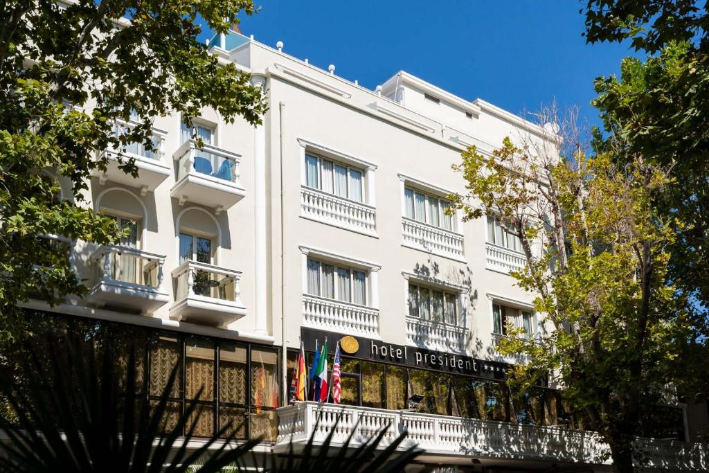 Ein weißes Gebäude mit einem Schild, das den Präsidenten des Hotels liest. in der Unterkunft Hotel President in Rimini