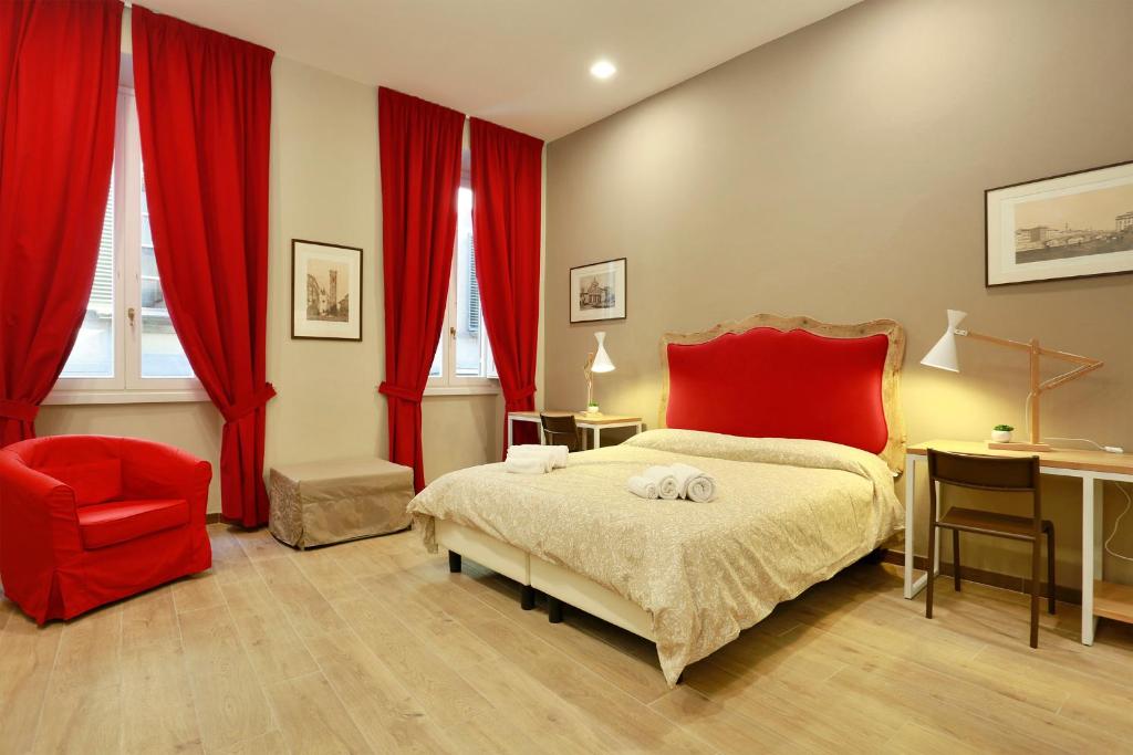 a bedroom with a red bed and a red chair at Tornabuoni Boutique in Florence